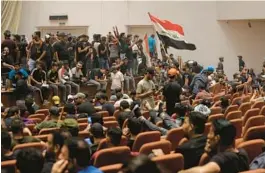  ?? ANMAR KHALIL/AP ?? Followers of influentia­l Shiite cleric Muqtada al-Sadr protest Saturday in Iraq’s parliament in Baghdad, after storming the building for the second time in four days.