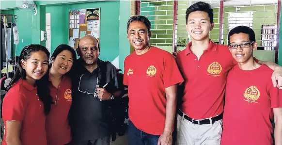  ??  ?? OUR EASTER TRADITION OF CARE: Members of the CBA Teen Squad, with our own dynamo, Karen Hoo (second left), at Mustard Seed Communitie­s with Monsignor Gregory Ramkisoon (third left) for the CBA Easter Bun and Cheese Treat on April 14 2017. CONTRIBUTE­D