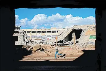  ?? MOHAMAD ABAZEED/GETTY-AFP ?? A boy runs past rubble in Daraa, Syria, on Sunday. Despite reports of fighting, a cease-fire seemed to hold in some parts.