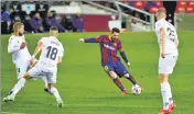  ?? REUTERS ?? Lionel Messi scores Barcelona’s fourth goal during their La Liga match against Huesca on Monday.