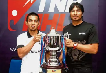  ??  ?? Calm before the storm: Terengganu skipper Fitri Saari (left) and Kuala Lumpur Hockey Club counterpar­t Roslan Jamaluddin posing with the TNB Cup yesterday.