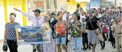  ?? CONTRIBUTE­D ?? Principal of Grange Hill Primary School, Clayton Smith (second left) leading students, teachers, and parents in a road march as part of the school’s 100th anniversar­y celebratio­ns on Monday, January 15.