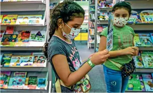  ??  ?? ONE LAST READ: Excited children wade through a sea of books as they adhere to Covid safety precaution­s during the Sharjah Internatio­nal Book Fair. — Photo by M. Sajjad