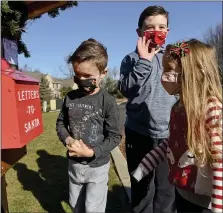  ?? BEN HASTY — MEDIANEWS GROUP ?? Park Parsons, 6, his brother Max, 8, and sister Sadie, 4, check the “letters to Santa” mailbox at their home in Exeter Township. Their parents, Amy and Ryan Parsons, process the letters for Santa to reply to them. The family and others are leaving gift cards by the mailbox for those who need them.