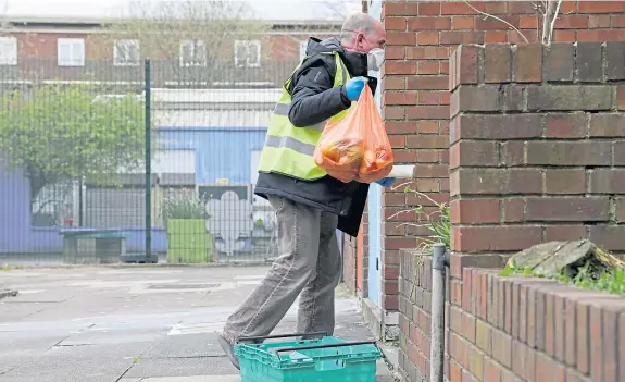  ?? Pictures: Shuttersto­ck. ?? A volunteer from a distributi­on hub delivers food to a vulnerable person in London.