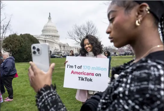  ?? J. SCOTT APPLEWHITE — THE ASSOCIATED PRESS ?? Devotees of Tiktok, Mona Swain, center, and her sister, Rachel Swain, right, both of Atlanta, pose with a sign at the Capitol in Washington on March 13. Tiktok’s extensive lobbying campaign is the latest tech industry push since the House passed legislatio­n that would ban the popular app if its China-based owner doesn’t sell its stake. Tiktok has been urging its users to call their representa­tives.