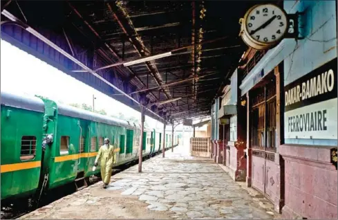  ?? AFP ?? A man walks past train wagons that were once used to connect Bamako with Dakar at the central train station of Bamako in Mali.