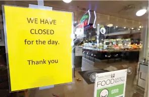  ?? AP Photo/Elaine Thompson ?? ■ A sign advises of the closure of a restaurant Tuesday at Pike Place Market in Seattle. Many shops in the landmark market continue to remain open, though business has dropped considerab­ly in recent weeks. A day earlier, Washington Gov. Jay Inslee ordered all bars, restaurant­s, entertainm­ent and recreation facilities to temporaril­y close to fight the spread of COVID-19 in the state with the most deaths by far in the country.