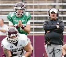  ?? ?? Quarterbac­k Conner Weigman, left, returned to the field under the watchful eye of Texas A&M coach Mike Elko.