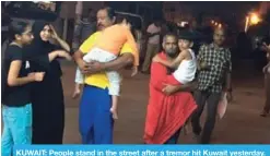  ??  ?? KUWAIT: People stand in the street after a tremor hit Kuwait yesterday.