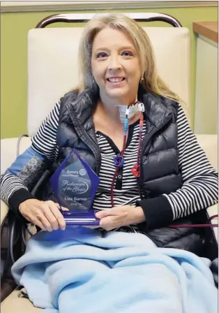  ?? STACI VANDAGRIFF/RIVER VALLEY & OZARK EDITION ?? Lisa Garner holds her Rotarian of the Year award as she receives dialysis in Conway. Garner underwent a kidney transplant about 12 years ago, but she is in kidney failure and is awaiting a donor. Despite her health issues, according to the Conway Noon Rotary Club, she has been an invaluable member. Garner works with legislator­s on Capitol Hill to get the Living Donor Protection Act of 2019 passed so kidney donors are guaranteed their jobs after time off to make the donation.