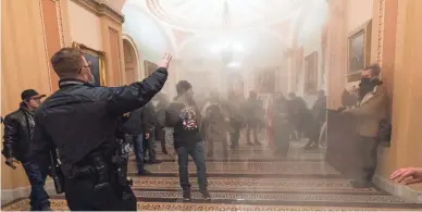  ?? MANUEL BALCE CENETA/AP FILE ?? Smoke fills a walkway in the U.S. Capitol as protesters are confronted by Capitol Police on Jan. 6.