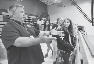  ?? Jerry Baker ?? Kingwood High School history teacher David Knight, from left, checks out the school's main gym with Marissa Amar, 17, Abigail McCollum, 16, and Leah Sanders. Closed by Hurricane Harvey floodwater­s, the high school is reopening to students on March 19.