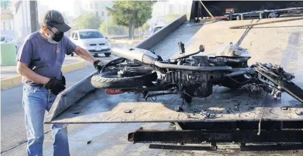  ?? FOTO: MARCO MILLÁN ?? > Un operador de grúa procede a retirar la motociclet­a del lugar.