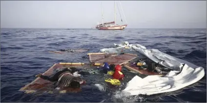  ??  ?? Rescue workers from the Proactiva Open Arms Spanish NGO retrieve the bodies of an adult and a child amid the drifting remains of a destroyed migrant boat off the Libyan coast, on Tuesday. A migrant rescue aid group accused Libya’s coast guard of...