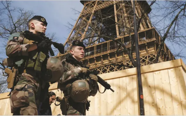 ?? ?? Armed soldiers patrol near the Eiffel Tower in Paris on Monday, after France raised its security threat level. REUTERS