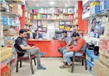  ??  ?? This photo taken on April 27, 2017 shows Indian Kashmiri men looking at their mobile phones in a shop in Srinagar.