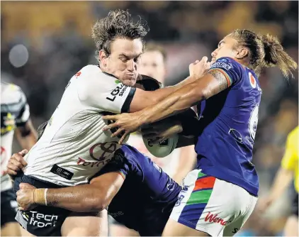  ?? PHOTO: GETTY IMAGES ?? Fendly gesture . . . Cowboys second rower Coen Hess (left) fends off Warriors half Chanel HarrisTavi­ta during their NRL clash at Mt Smart Stadium in Auckland on Saturday night. The Cowboys won 1710.