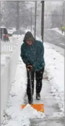  ?? PETE BANNAN – DIGITAL FIRST MEDIA ?? Dan Zwilling clears snow from in front of his Drexel Hill home Wednesday afternoon.