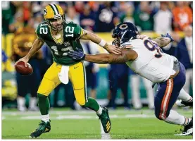  ?? DYLAN BUELL / GETTY IMAGES ?? Packers quarterbac­k Aaron Rodgers avoids being sacked by Akiem Hicks of the Bears during the first quarter of their game at Lambeau Field on Sunday in Green Bay, Wisconsin.