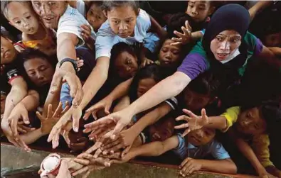  ?? REUTERS PIC ?? People displaced by the terror attacks in the southern Philippine city of Marawi reaching out for ice cream at an evacuation centre yesterday.