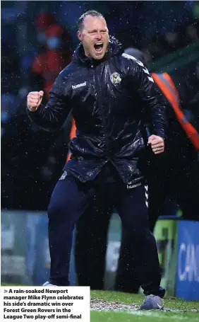  ??  ?? > A rain-soaked Newport manager Mike Flynn celebrates his side’s dramatic win over Forest Green Rovers in the League Two play-off semi-final