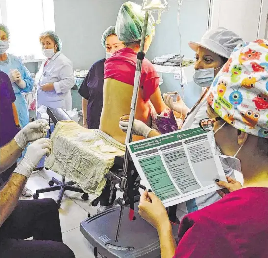  ?? Gordon Yuill/lifebox / New York Times ?? Participan­ts in a workshop in Yerevan, Armenia, review the World Health Organizati­on’s surgical safety checklist while preparing to administer anesthesia for a C-section.