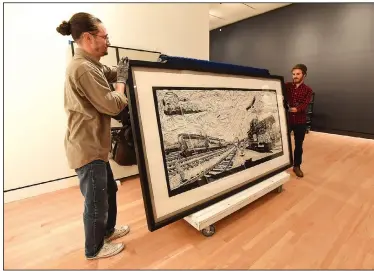 ?? NWA Democrat-Gazette/FLIP PUTTHOFF ?? Drew Divilbiss (left) and Michael Derian move a piece of art Wednesday at Crystal Bridges Museum of American Art in Bentonvill­e. Several works that have been on the road at other museums are now back at Crystal Bridges.