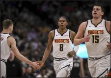  ?? AARON ONTIVEROZ — THE DENVER POST ?? Denver’s Peyton Watson, center, shakes hands with Christian Braun as he runs back with Nikola Jokic against the San Antonio Spurs at Ball Arena on Tuesday night.