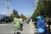  ?? OMID HAQJOO — THE ASSOCIATED PRESS ?? Afghan people run near the site of an explosion in Herat province, Afghanista­n, on Friday.