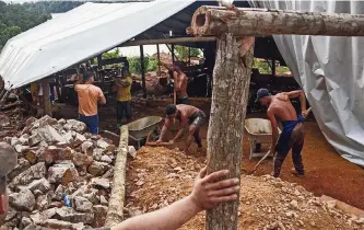  ?? ?? MINEROS DE oro trabajando en una pequeña mina en Surinam. Los mineros utilizan mercurio para separar el oro del lodo