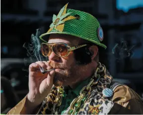  ?? CP PHOTO ?? Cannabis user Scott Wells smokes a joint at a rally outside the government offices in Calgary following the legalizati­on of cannabis on Wednesday.