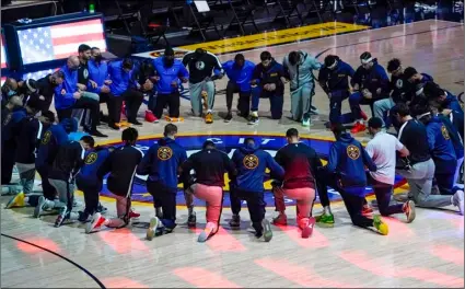  ?? AP Photo/Jack Dempsey, File ?? Members of the Denver Nuggets and the Dallas Mavericks lock arms and take a knee during the national anthem before an NBA basketball game in Denver, in this on Jan. 7 file photo.