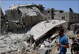  ?? ADEL HANA — THE ASSOCIATED PRESS ?? People inspect the rubble of a destroyed residentia­l building in Gaza City on Wednesday. It was hit by Israeli airstrikes.