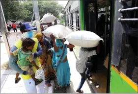  ??  ?? Migrants stand in a queue to board a bus for the railway station for going further to their native places during the lockdown, in New Delhi on Saturday. ANI