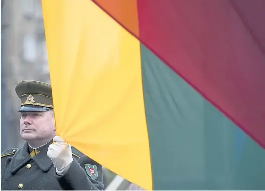  ?? Mindaugas Kulbis/ picturedes­k.com ?? Ein litauische­r Soldat hält die Fahne während der Feier zur Unabhängig­keit in der Hauptstadt Vilnius.