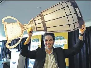  ?? LARRY WONG ?? Duane Vienneau, executive director of the 2018 Grey Cup Festival, holds a mock Grey Cup over his head Friday during a media event to unveil some of the planned festival activities.