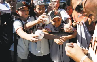  ??  ?? Fans mill around the field at Giants FanFest, eating, meeting players and visiting parts of AT&amp;T Park that are usually off limits. Reliever Javier Lopez signs autographs for fans during Giants FanFest at AT&amp;T Park, but he also took the time to tweak his former teammate, Jeremy Affeldt, who retired after the season.