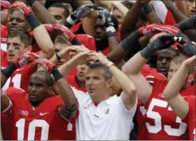  ?? JAY LAPRETE — THE ASSOCIATED PRESS FILE ?? In this file photo, Ohio State NCAA college football head coach Urban Meyer leads the team in singing Carmen Ohio after beating Miami of Ohio 56-10, in Columbus, Ohio. Ohio State suspended coach Urban Meyer for three games on Wednesday night for mishandlin­g repeated profession­al and behavioral problems of an assistant coach, with investigat­ors finding Meyer protected his protege for years through domestic violence allegation­s, a drug problem and poor job performanc­e. The superstar coach’s treatment of his now-fired assistant was also clouded by his abiding devotion to the legacy of former Ohio State coach Earle Bruce, the grandfathe­r of former wide receivers coach Zach Smith and an early coaching mentor for Meyer.