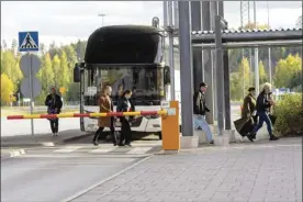  ?? Lauri Heino / Lehtikuva photo via AP ?? People get off a bus to cross the border from Russia to Finland at the Nuijamaa border check point in Lappeenran­ta, Finland on Thursday.