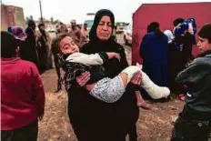  ?? Reuters ?? A woman carries her injured daughter at a screening centre in western Mosul.