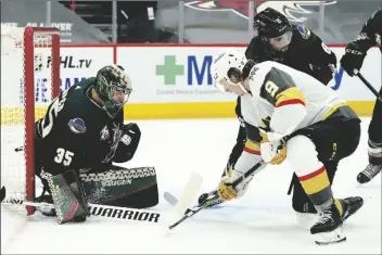  ?? ASSOCIATED PRESS ?? ARIZONA COYOTES GOALTENDER DARCY KUEMPER (35) makes a save on a shot by Vegas Golden Knights center Cody Glass (9) as Coyotes center Nick Schmaltz (8) defends during the second period of a game on Friday in Glendale.