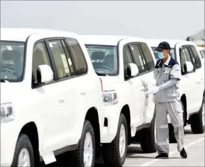  ?? LI RAN / XINHUA ?? A port employee checks vehicles imported from Japan at Tianjin Port.