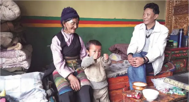  ?? PHOTOS BY PALDEN NYIMA / CHINA DAILY ?? Phurbu Tsering (right) visits a family in the Ta village in Gyirong county, the Tibet autonomous region.