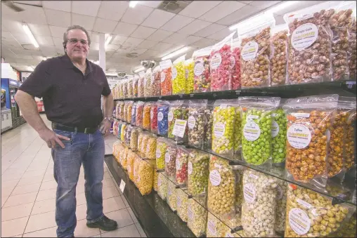  ?? (Livingston County Daily Press & Argus/Gillis Benedict) ?? Stephen Canale stands by the wide selection of his gourmet popcorn in Middletown Market in Genoa Township, Mich. The market, which features an entire aisle of It’s So Fluffy popcorn flavors, is among a growing list of local retailers carrying his products.