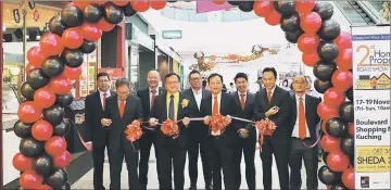  ??  ?? Lo (front, second left) and Sim (front, third left) jointly cut the ribbon to mark the opening of the property roadshow at Boulevard Shopping Mall in Kuching.