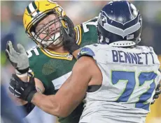  ?? MARK HOFFMAN / MILWAUKEE JOURNAL SENTINEL ?? Packers tackle Bryan Bulaga blocks Seahawks defensive end Michael Bennett last season. Bulaga is listed as questionab­le for the game against the Seahawks at 3:25 p.m. Sunday