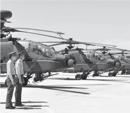  ?? AFP PHOTO ?? TANK KILLERS Two Taiwan servicemen stand in front of US-made Apache AH-64E attack helicopter­s during a commission­ing ceremony at a military base in Taoyuan on Tuesday.