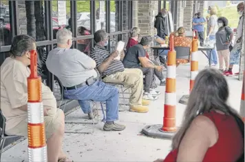  ?? Nati Harnik / Associated Press ?? More than a million Americans sought unemployme­nt benefits last week. Above, job seekers exercise social distancing as they wait to be called into the Heartland Workforce Solutions office in Omaha, Neb., on Wednesday.