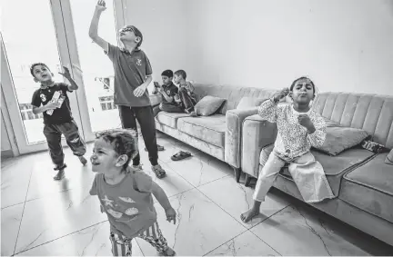  ?? MARCUS YAM TNS ?? Fatma “Battahâ” Nabhan, right, plays with her siblings at their temporary apartment in Qatar.